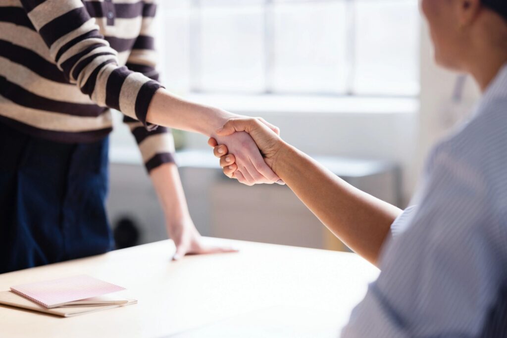 Business Handshake Between Colleagues in Office Meeting